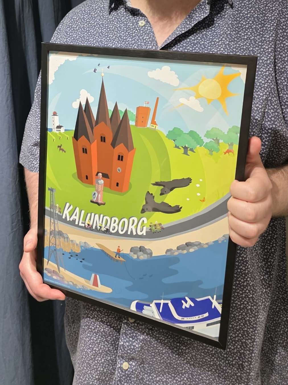 The Kalundborg poster in a black frame, held by Martin Fredskov